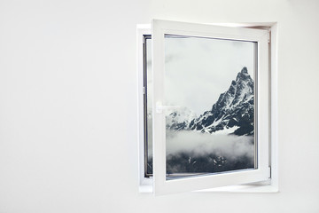 Open window with white wall and mountains view