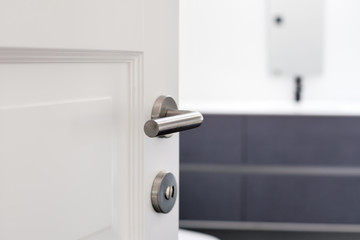 Fototapeta premium Open white door with metallic handle