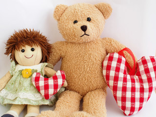 Little girl's toys - a doll and a teddy bear with soft stuffed hearts