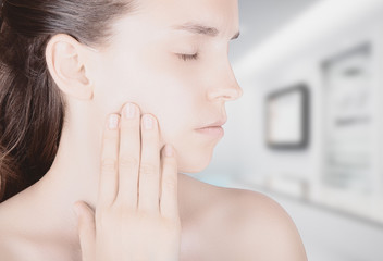 Viso donna con dolore denti sfondo ambulatorio © Aldeca Productions