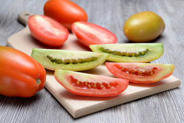 Pomodori lunghi tagliati a spicchi su tagliere di legno