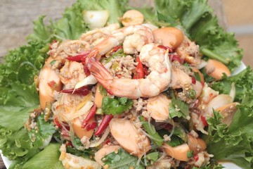 Spicy seafood noodle with green leafy vegetables.