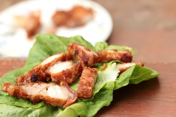 Pork fried with vegetables on wood background.