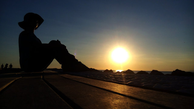 Donna con cappello al tramonto