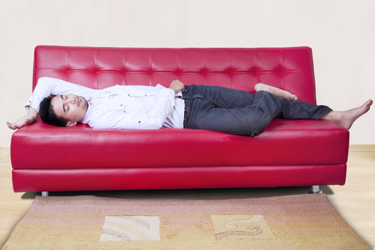 Man Napping On The Red Sofa