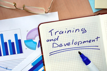 Notepad with words training and development  concept and marker.