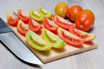 Pomodori lunghi tagliati a spicchi su tagliere di legno