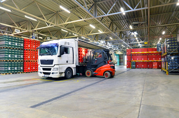 shipping - loading of a truck in a warehouse by forklift - obrazy, fototapety, plakaty