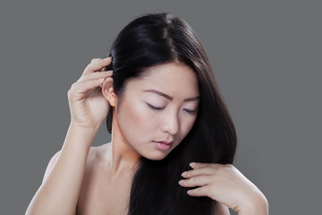 Naklejka premium Woman with long hair on grey background