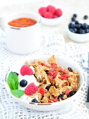 Healthy breakfast, yogurt with granola and berries on the white table