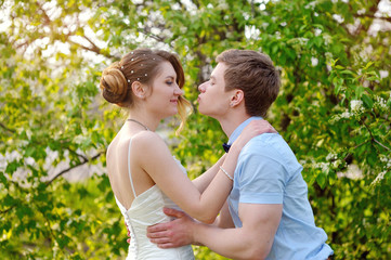 Fototapeta premium bride and groom kissing in the spring garden