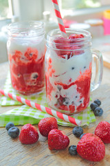 Fresh strawberry milkshake in glass with color sipper
