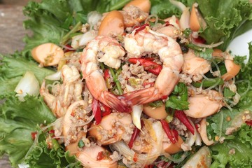 Spicy seafood noodle with green leafy vegetables.