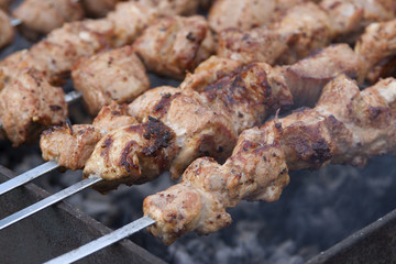 Shish kebab on skewers in the process of cooking over the coals