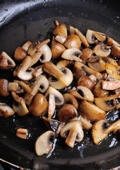 Fried sliced mushrooms in butter in a frying pan