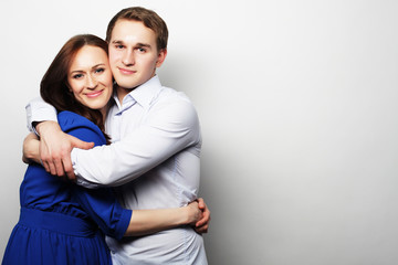 lovely happy couple hugging over grey background.