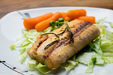 Salmon fillets served on a plate with mixed salad