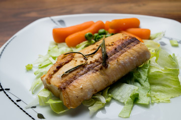 Salmon fillets served on a plate with mixed salad