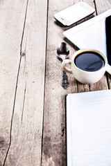 desk with a cup of coffee, a notebook and pen