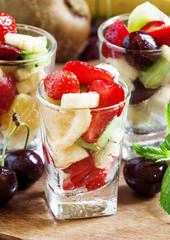 Salad from fruit and berries in glasses, selective focus