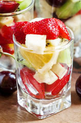 Salad from fruit and berries in glasses, selective focus
