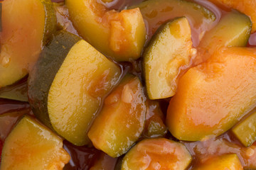 Chunks of zucchini in tomato sauce close view