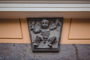 Small sculpture of a baby boy above the entrance door.