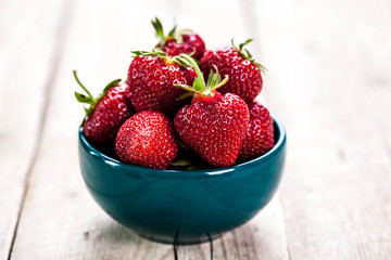 Red strawberries on blue clay plate. fruit