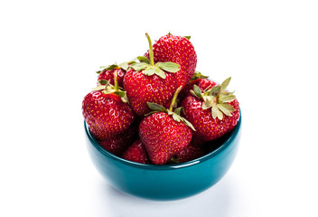 Red strawberries on blue clay plate