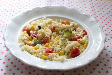couscous served with corns, zucchini and tomatoes