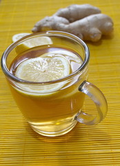lemon tea with lemon pieces and ginger on the table