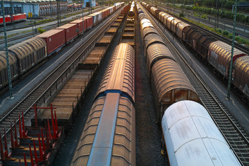 Fototapeta premium Sonnenuntergang am Rangierbahnhof mit Zügen, Waggons, Gütern