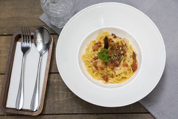 Dish of traditional spaghetti a la carbonara  with bacon , fork