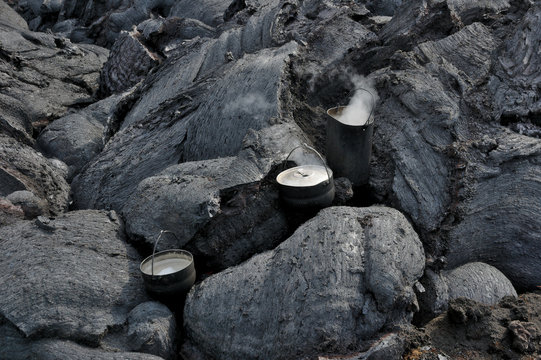 Water boiling in the travel saucepans installed upon the cooling lava stream
