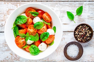 salad of mozzarella, cherry tomatoes and spinach with salt and pepper