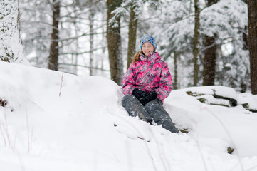 pretty teen girl playing out in a beautiful snowy forest