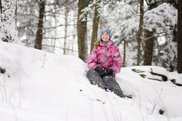 pretty teen girl playing out in a beautiful snowy forest