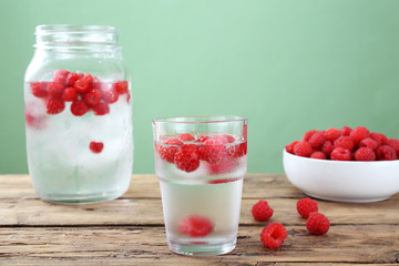 acqua ghiaccio e frutta lamponi sfondo verde