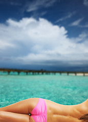 Fototapeta na wymiar Woman topless on beautiful beach with jetty