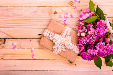 Obraz na płótnie Canvas Vintage background with a gift and flowers on a wooden surface