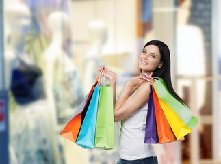 Beautiful smiling young woman with the colourful shopping bags from the fancy shops.