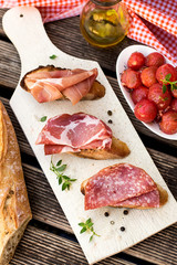 Italian bruschettas with ham prosciutto, coppa and salami