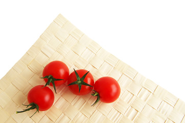 Cherry tomatoes on a wattled napkin on a white background. Tomatoes