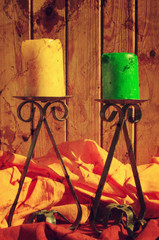 Two candlesticks with candles on a wooden background pleated bright yellow fabric in vintage style.