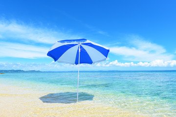 Fototapeta na wymiar 真夏の綺麗なビーチとパラソル