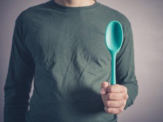 Young man holding a rubber spoon