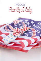 USA party table place setting with flag on white wood table.