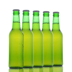 Five Green Beer Bottles with condensation and reflections isolated on white
