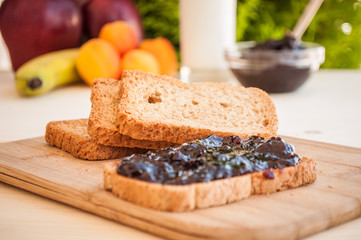 breakfast with sour cherry marmalade on toast with a glass of milk and frutis