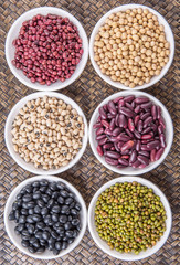 Beans variety in white bowl on in wicker tray